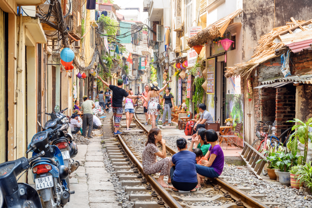 Pietoni pe o stradă din Hanoi, cu magazine