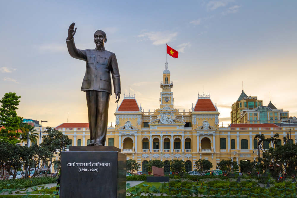 Statuie cu brațul ridicat, în fața unei clădiri monumentale.