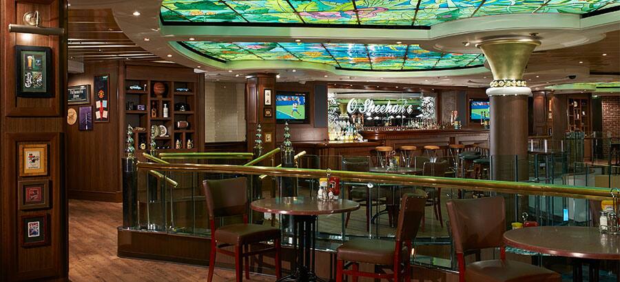 Bar cu balustrade metalice, scaune înalte și plafon decorativ verde.