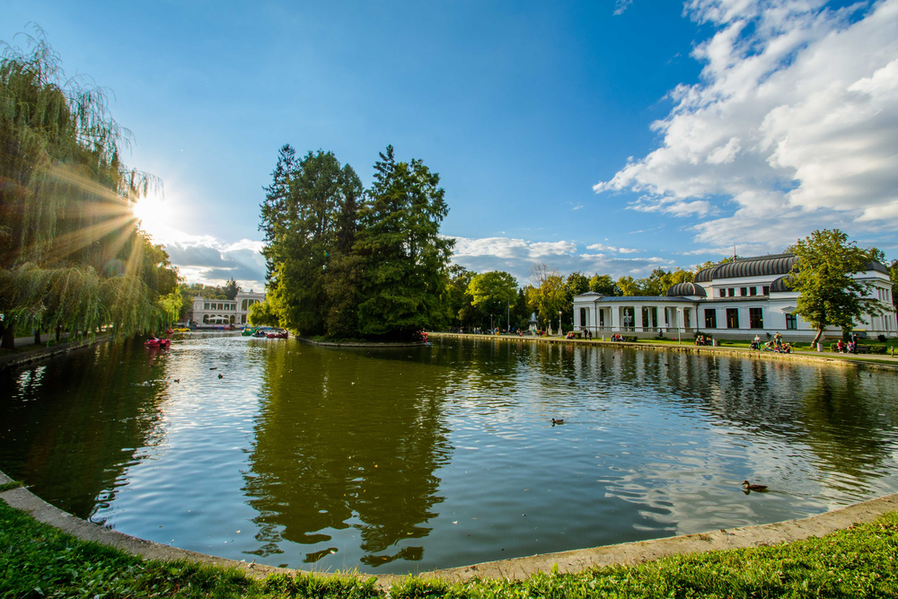 Lac într-un parc, lângă un pavilion cu coloane