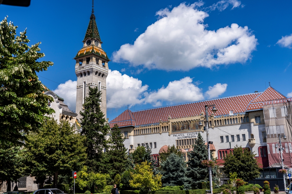 Turn cu acoperiș ascuțit lângă copaci și clădiri