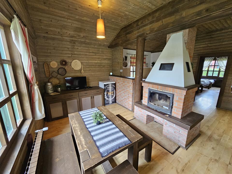 Interior rustic cu șemineu, masă și mobilier din lemn