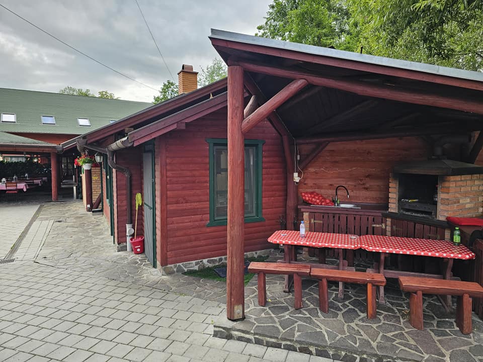 Verandă din lemn cu bănci și mese lungi