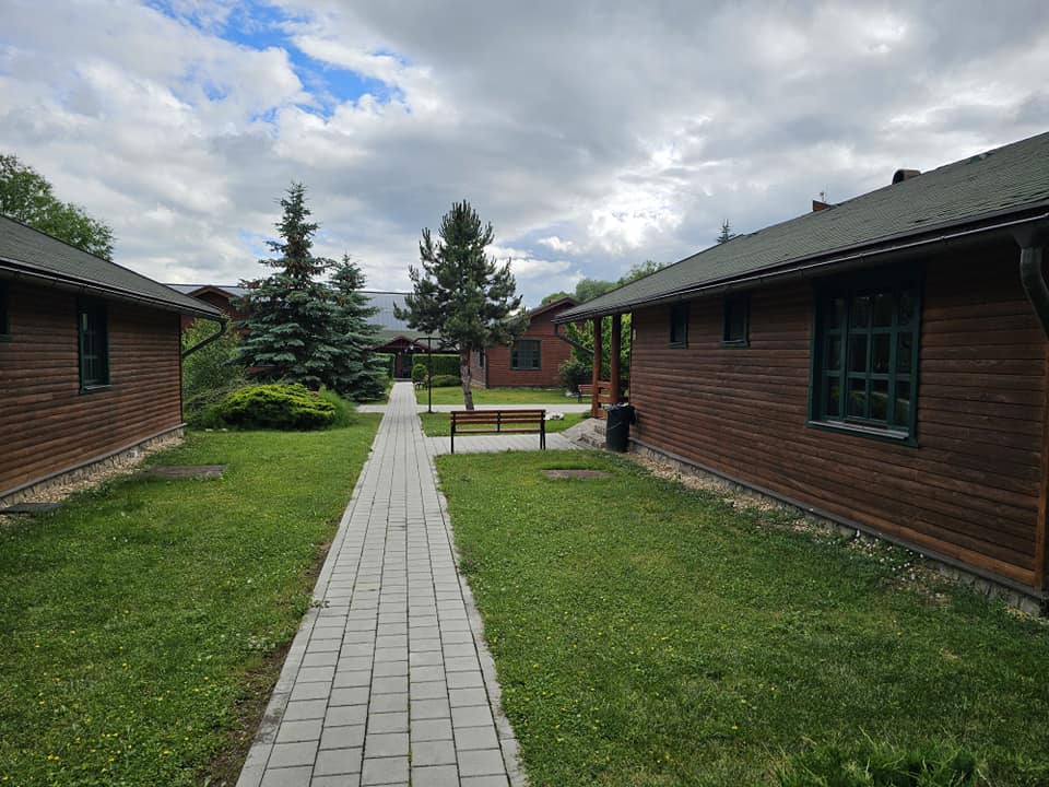 Alee de lemn printre cabane și peluze verzi