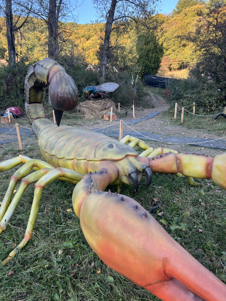 Sculptură de insectă cu picioare lungi într-un parc