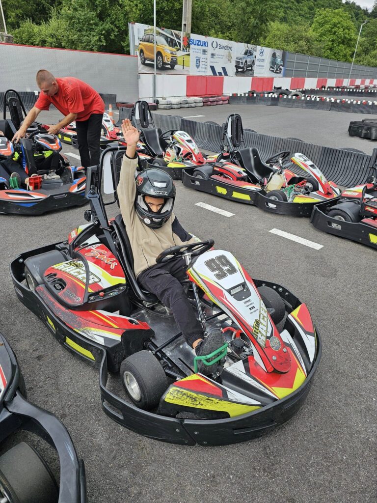 Persoane în karturi, lângă anvelopele unui circuit