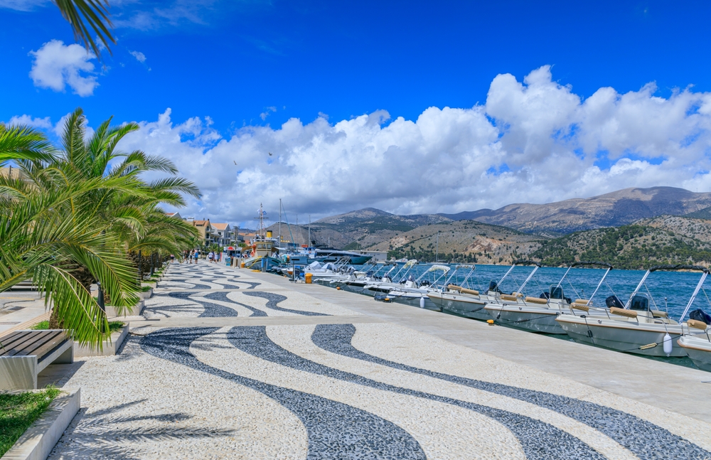 Promenadă cu palmieri și ambarcațiuni în Argostoli