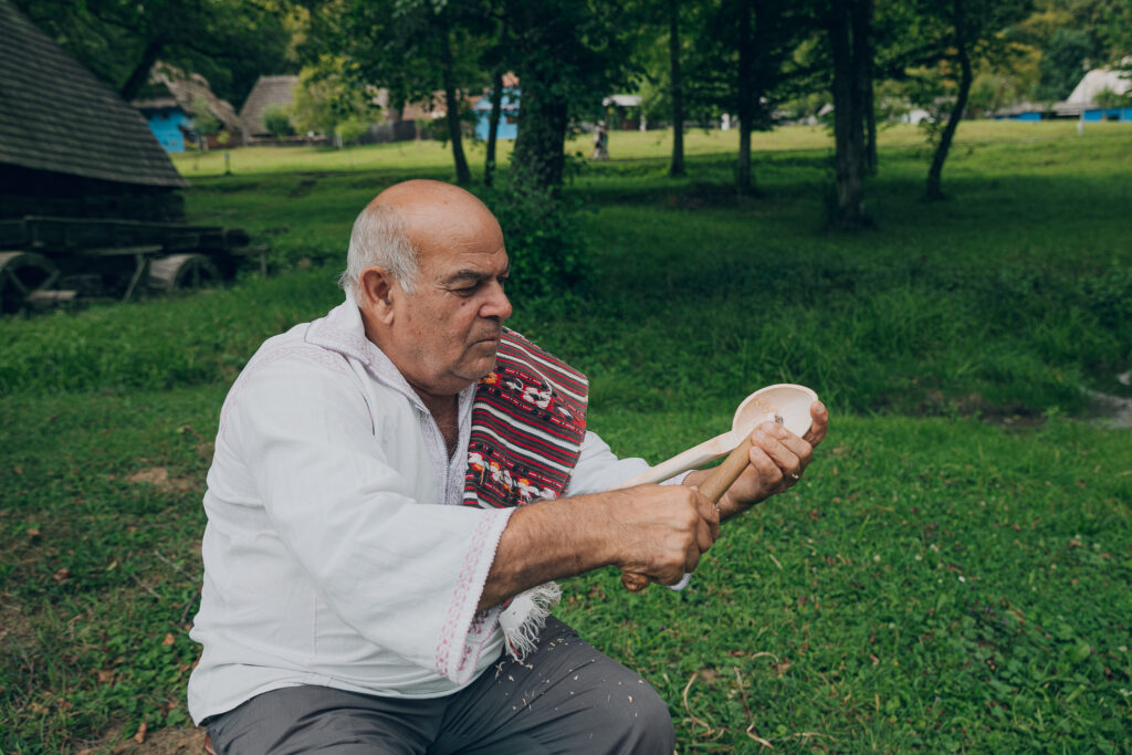 Bărbat ținând o piesă mică în mâini, pe iarbă