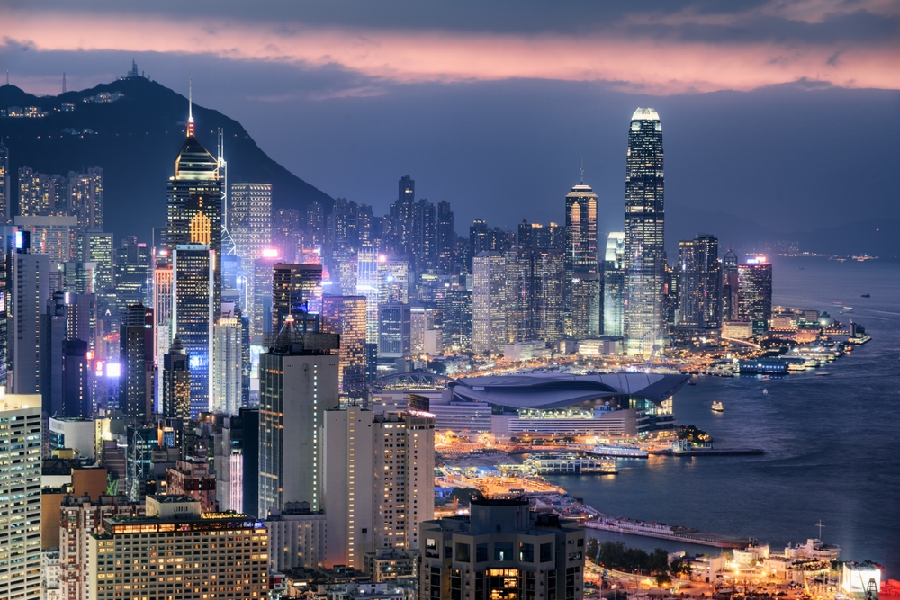 Clădiri iluminate în Hong Kong, lângă apă