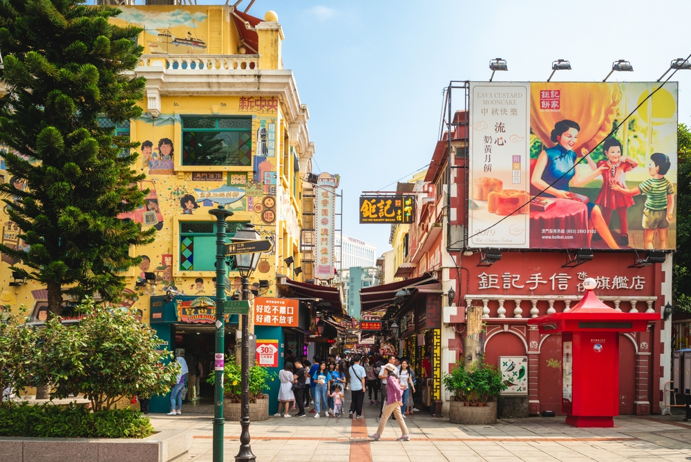 Pietoni și reclame colorate pe o stradă din Macao