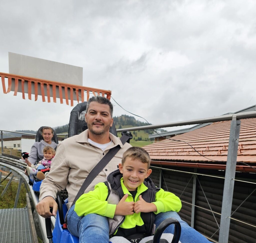 Adult și copil într-un bob lângă o clădire
