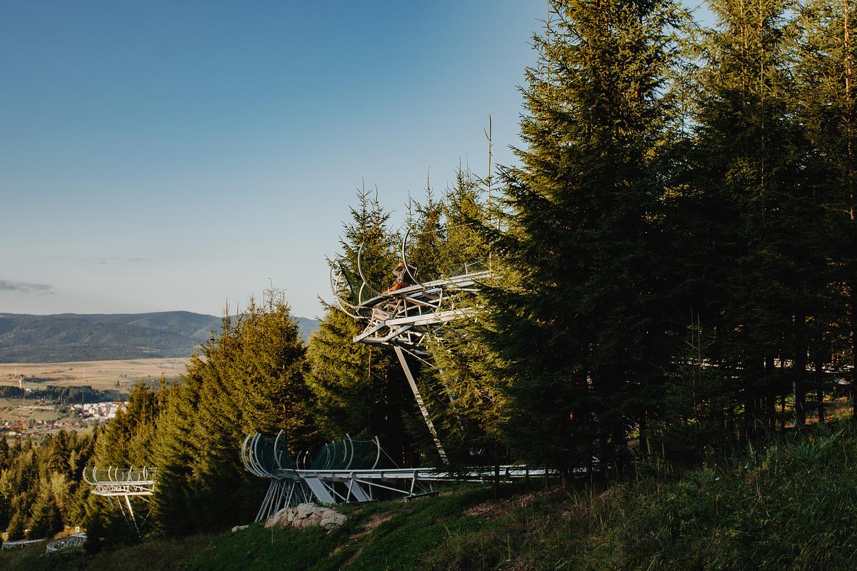 Traseu de bob printre arbori, cu vale în fundal
