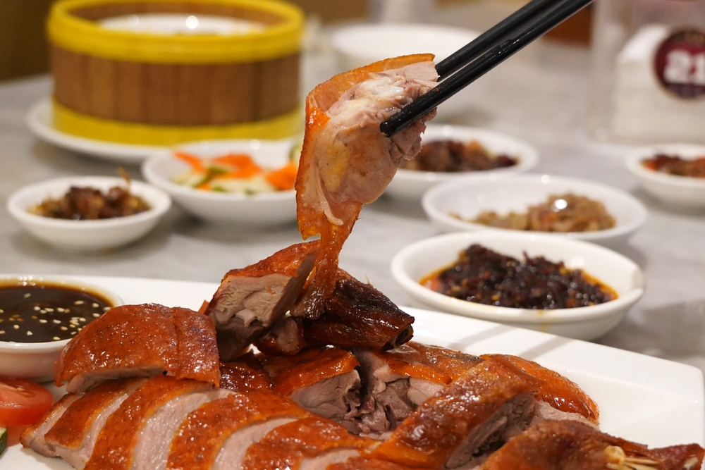 Felie de carne rumenită ridicată cu bețișoare deasupra unui platou