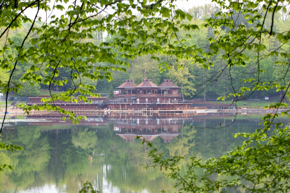 Lac și pavilion, văzute printre ramuri verzi