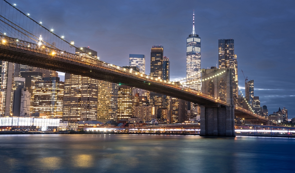 Podul Brooklyn iluminat seara, deasupra apei