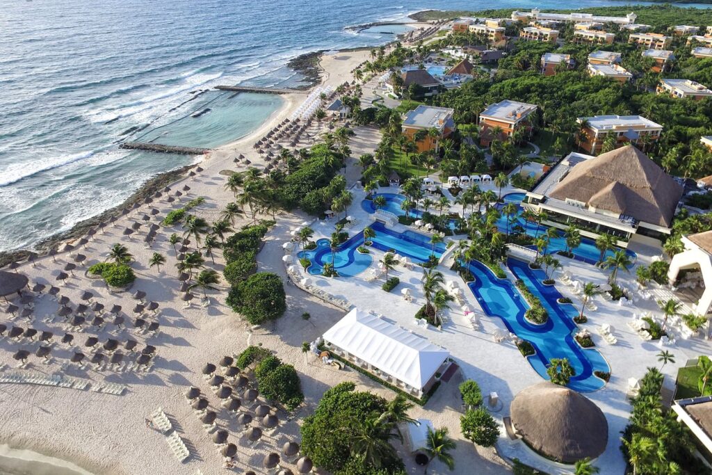 Piscine și clădiri de hotel lângă țărm, văzute de sus