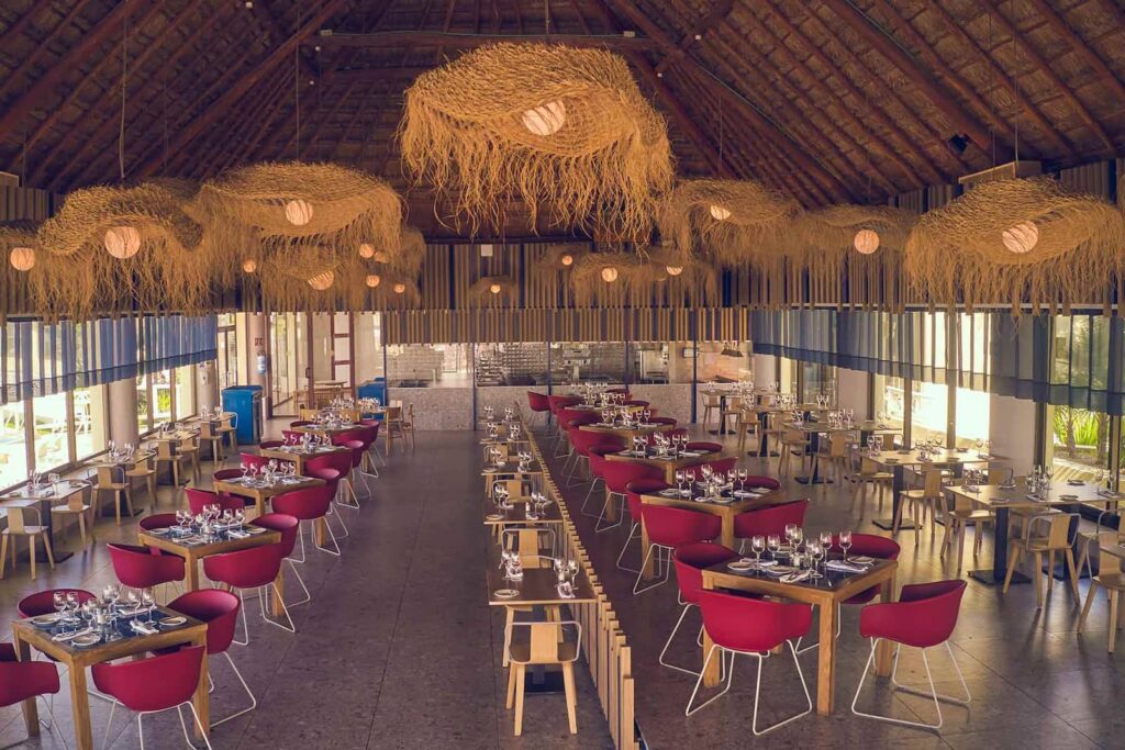 Sală de restaurant cu mese pregătite și acoperiș înalt