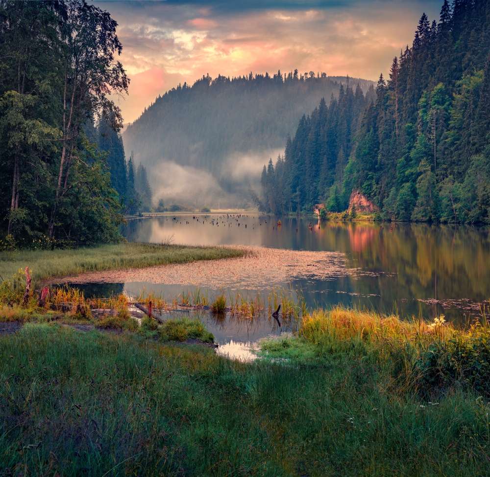 Lac montan la apus, între pădure și stânci