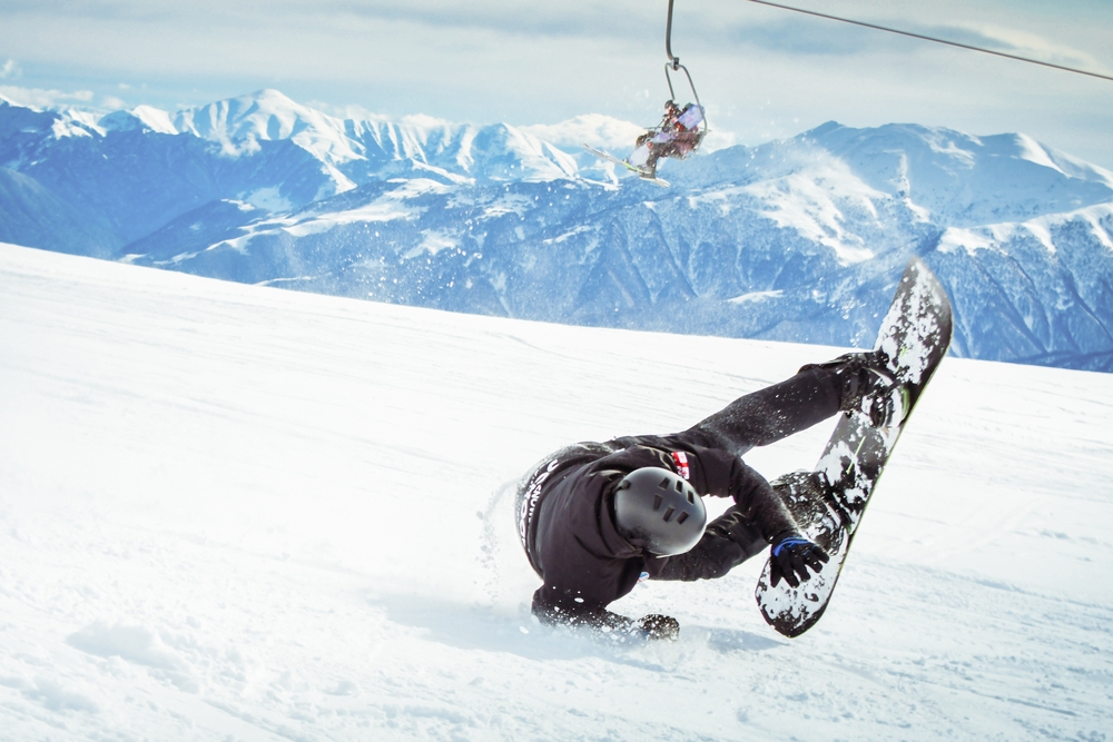 Persoană pe snowboard, pe o pantă înzăpezită