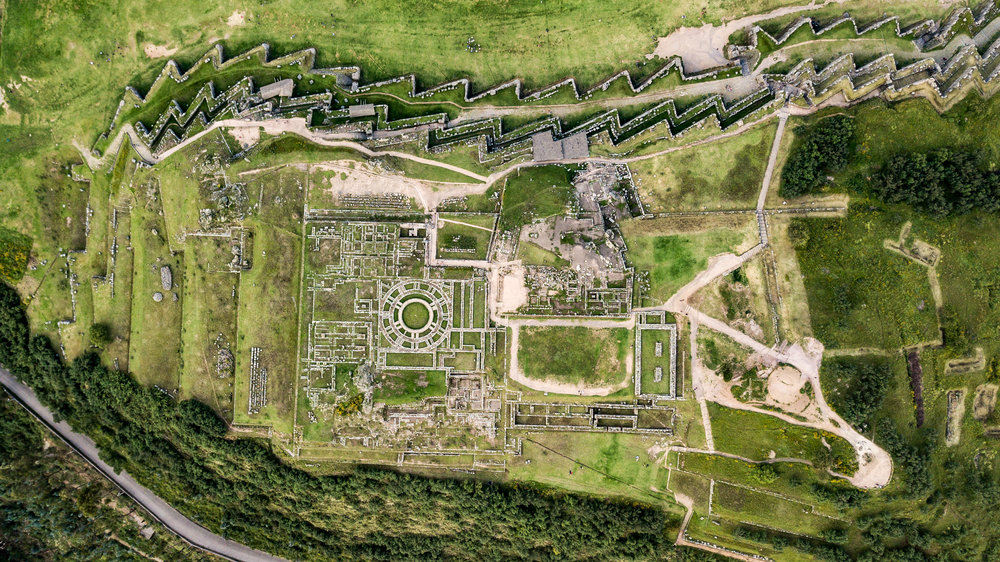 Ruine din piatră și terase verzi, văzute de sus