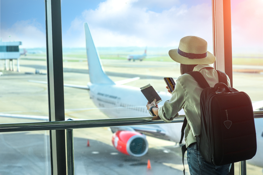 Călător cu rucsac lângă o fereastră spre avion