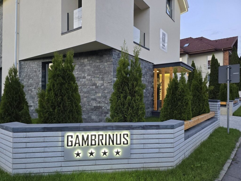 Fațada pensiunii Gambrinus, cu gard și vegetație