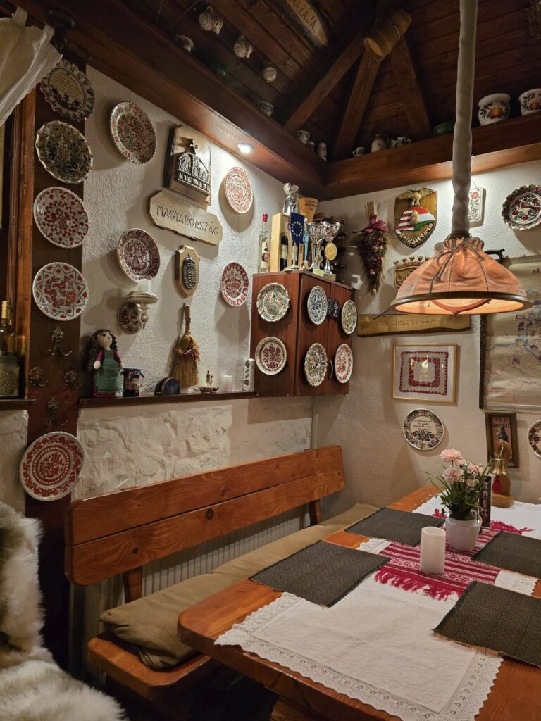 Sală rustică cu mese și farfurii decorative pe perete