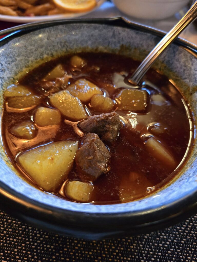 Tocană cu bucăți de carne și cartofi, într-un bol