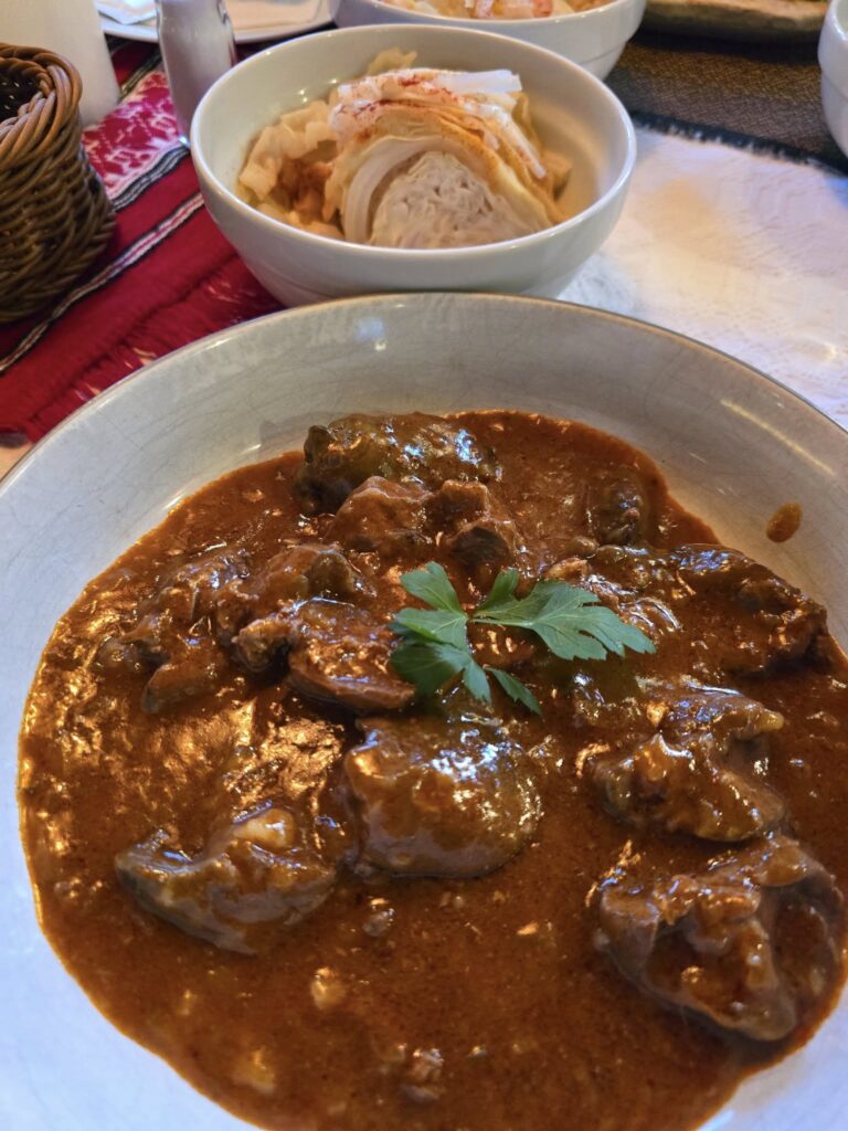 Preparat cu carne și sos, lângă un bol separat