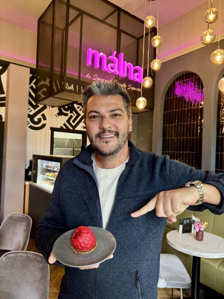 Bărbat cu o prăjitură roz, la masa cofetăriei