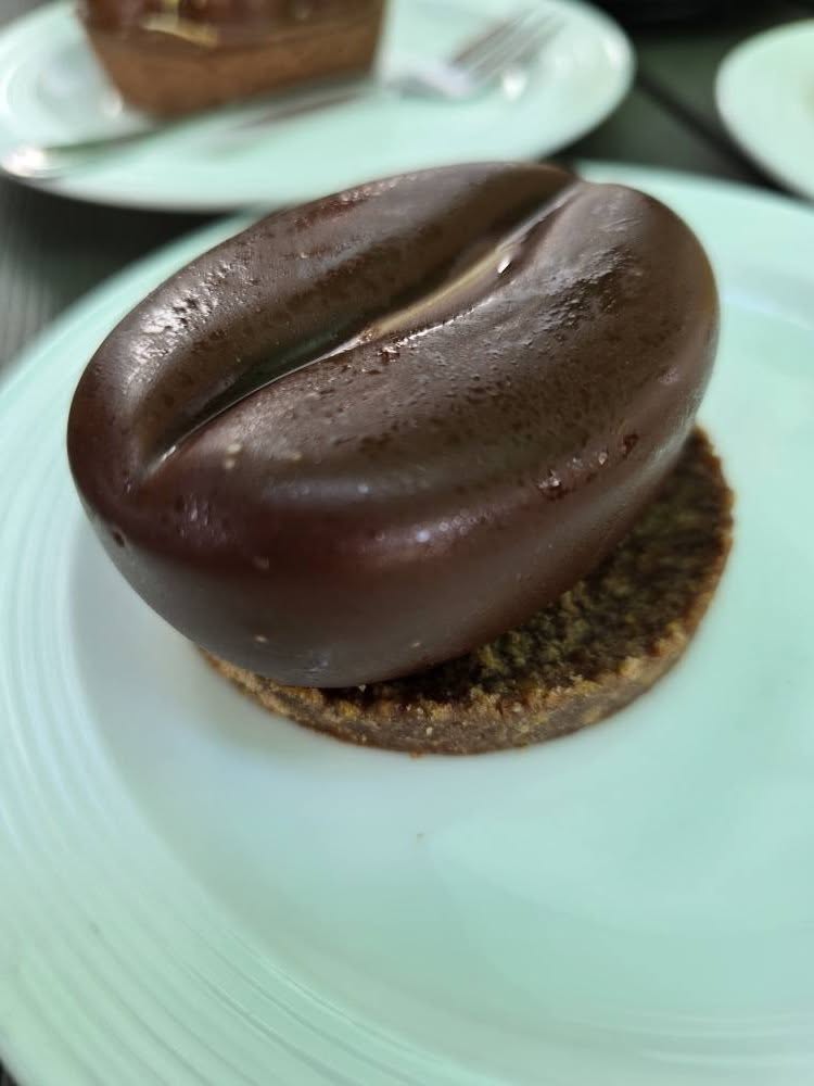 Desert rotund cu glazură de ciocolată pe farfurie