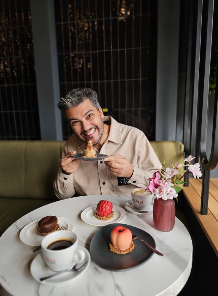 Bărbat așezat la o masă cu deserturi individuale