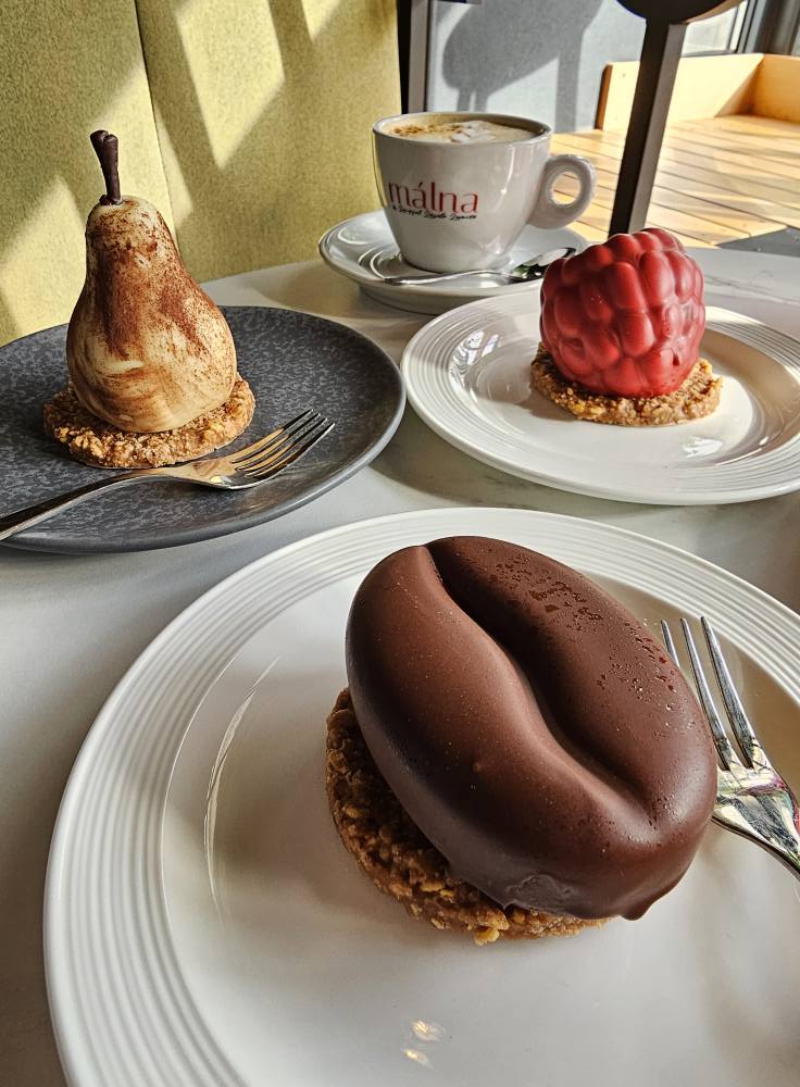 Desert glazurat cu ciocolată, lângă alte prăjituri
