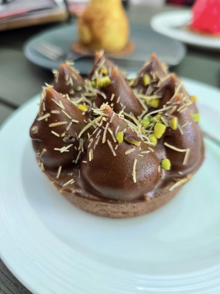 Desert cu cremă și ornamente, pe o farfurie albă