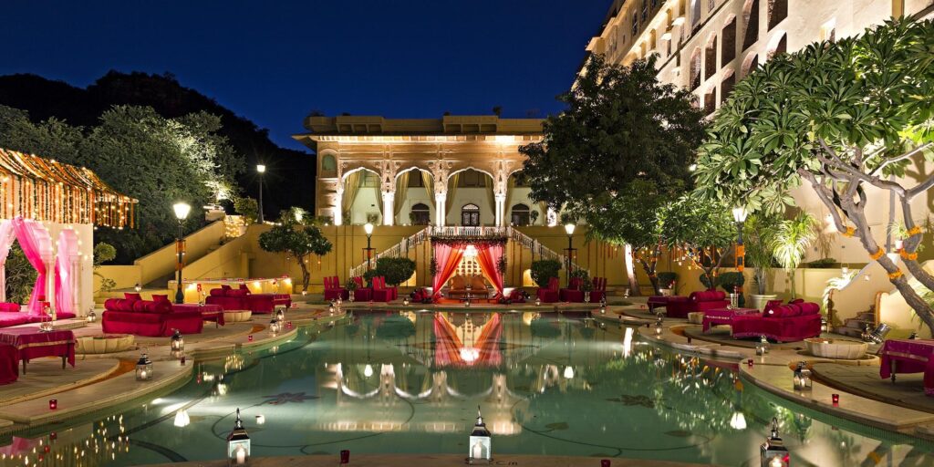 Piscină iluminată între clădiri și grădini, la palatul Samode
