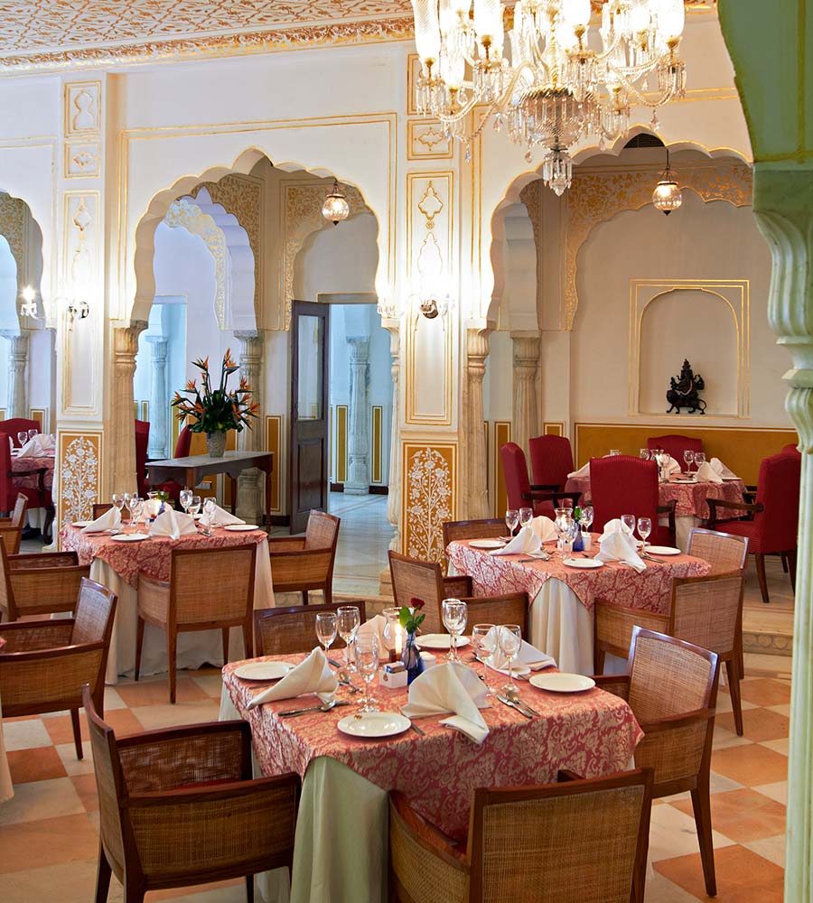 Mese pregătite într-un interior luminos cu coloane și arcade