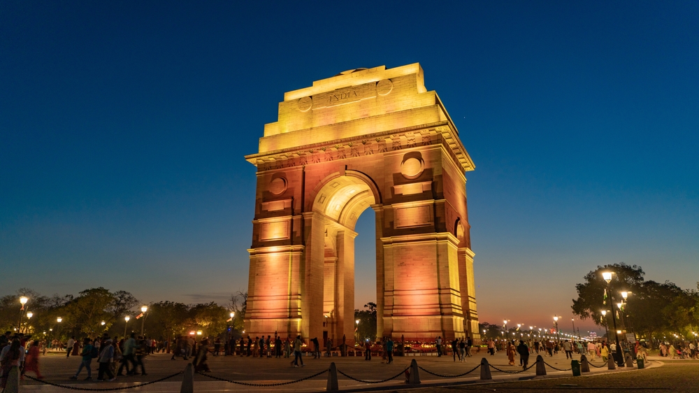 India Gate iluminată seara, într-o piață deschisă