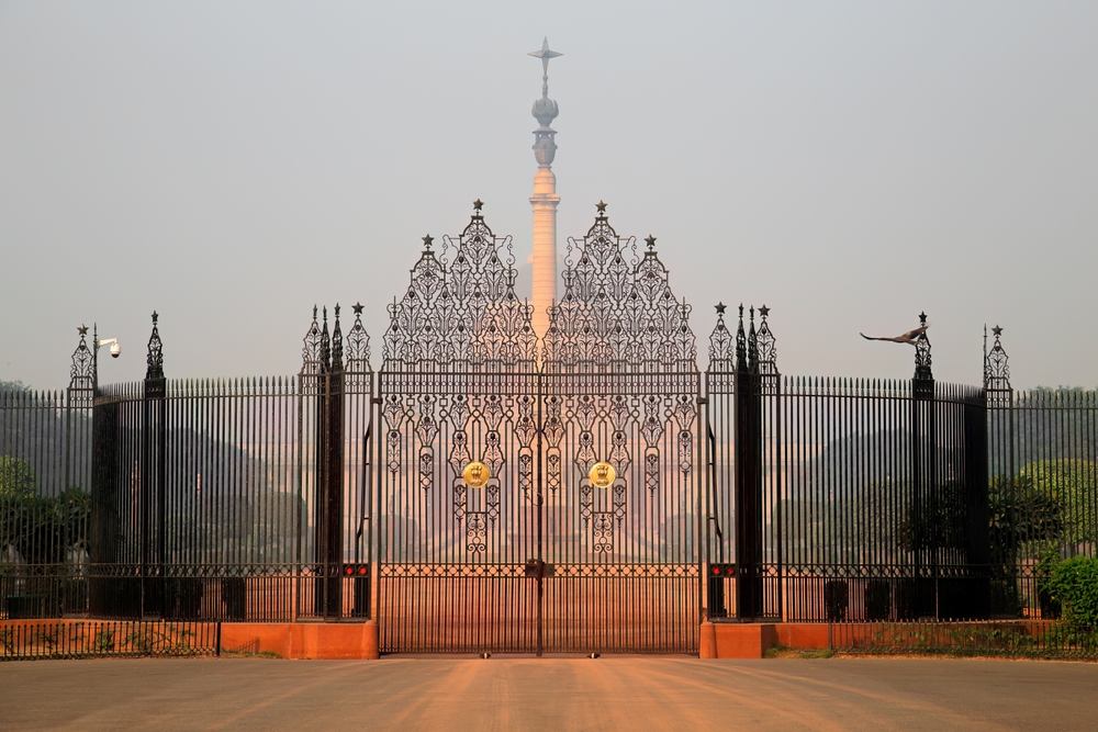Fațadă ornamentală cu turnulețe, văzută printr-un gard negru