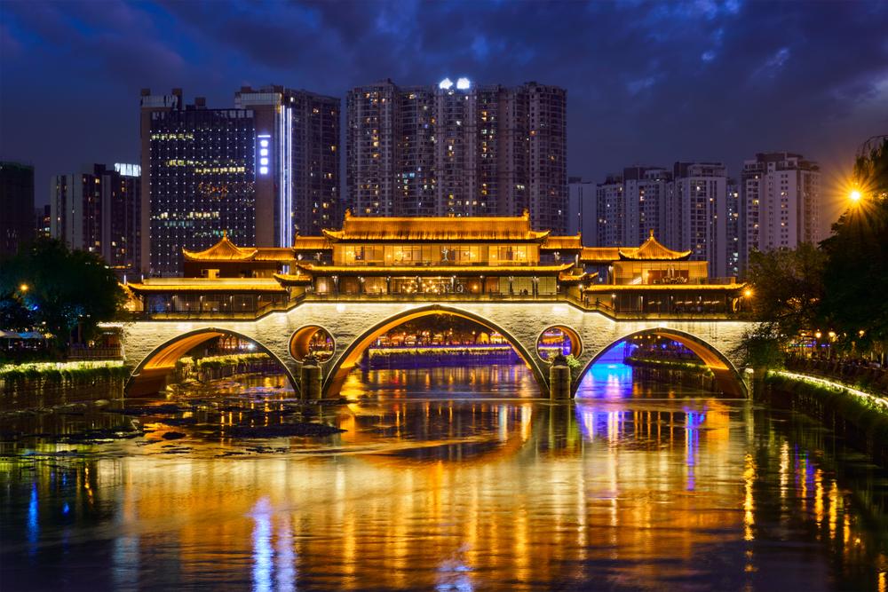 Pod și clădiri iluminate, reflectate în apă la Chengdu