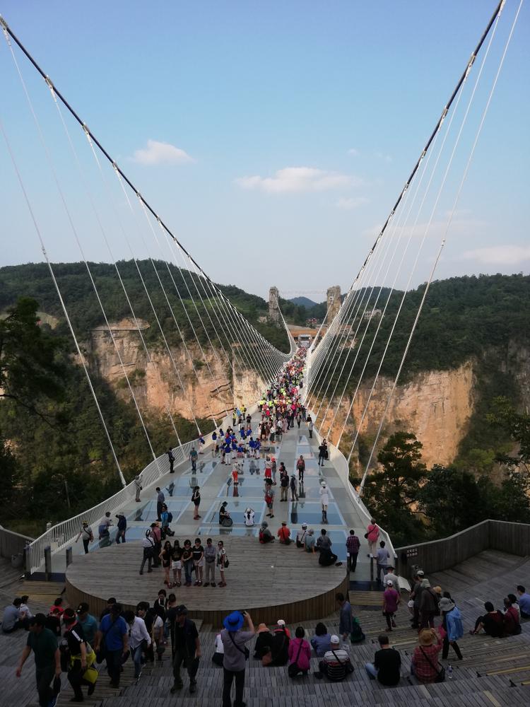 Vizitatori pe un pod suspendat între versanți