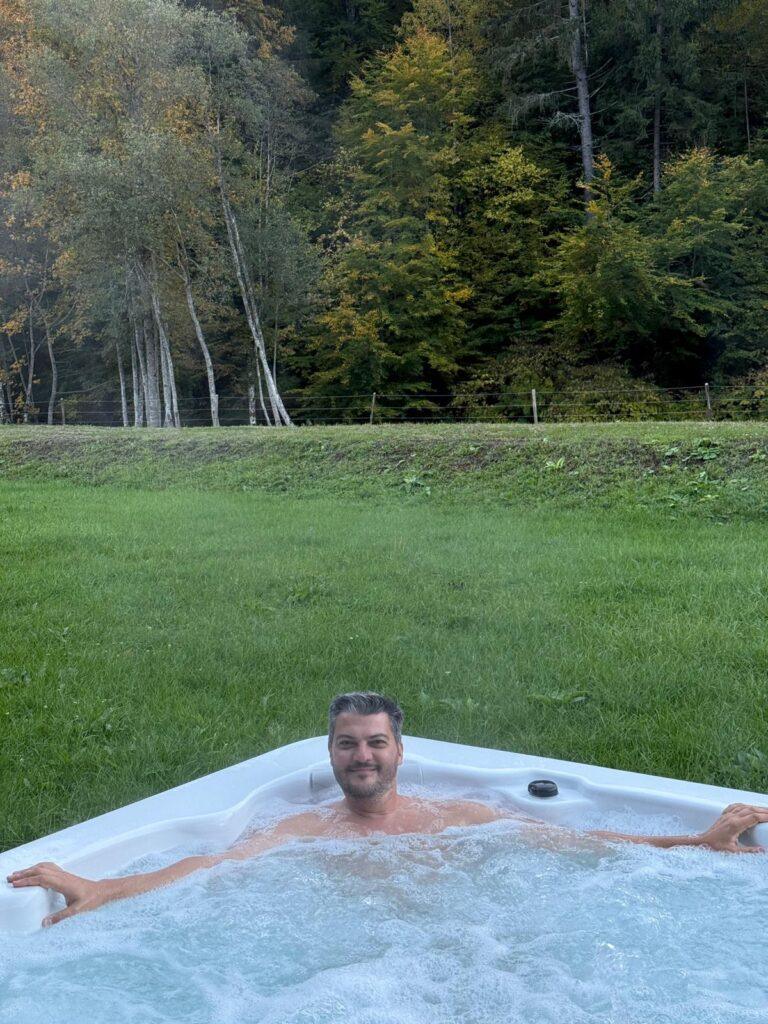 Persoană într-un bazin exterior, lângă pădure