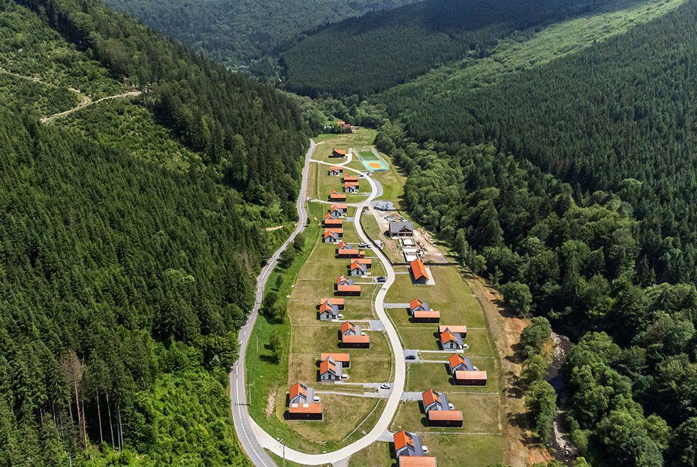 Complex de cabane într-o vale împădurită, văzut de sus