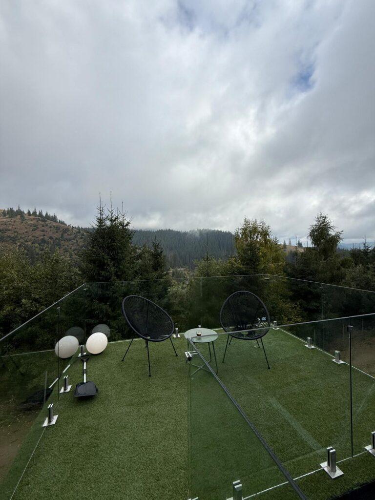 Grădină cu fotolii suspendate și vegetație verde