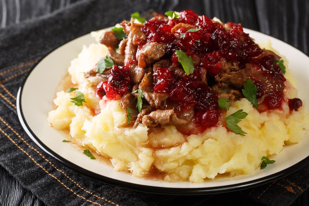 Piure cu carne și fructe roșii, servit pe farfurie