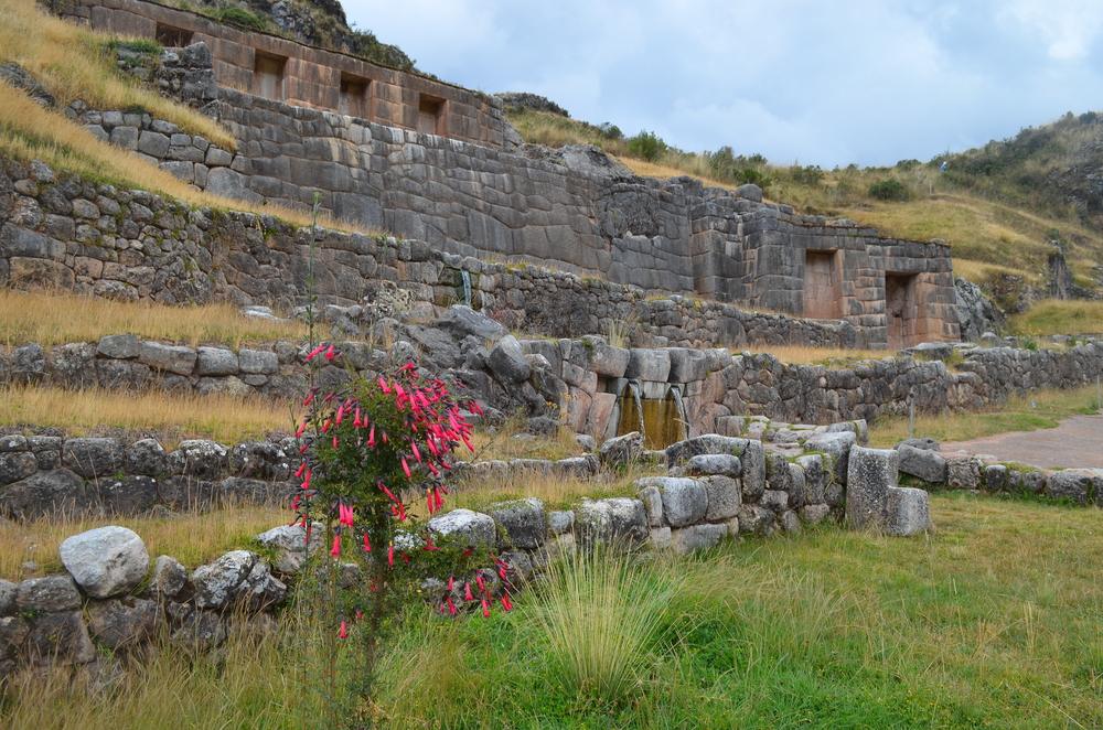 Ruine de piatră și terase pe un deal înverzit