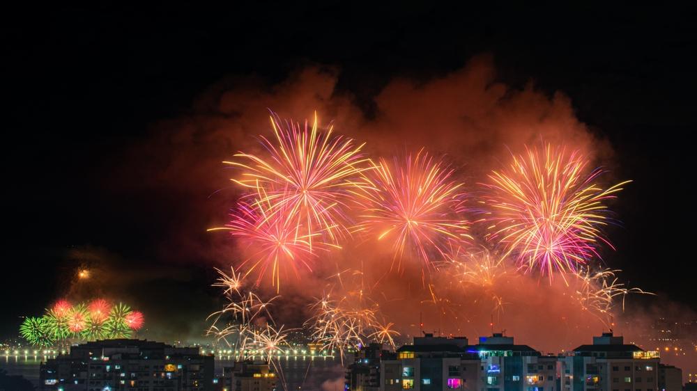 Artificii aurii deasupra unei zone iluminate, noaptea