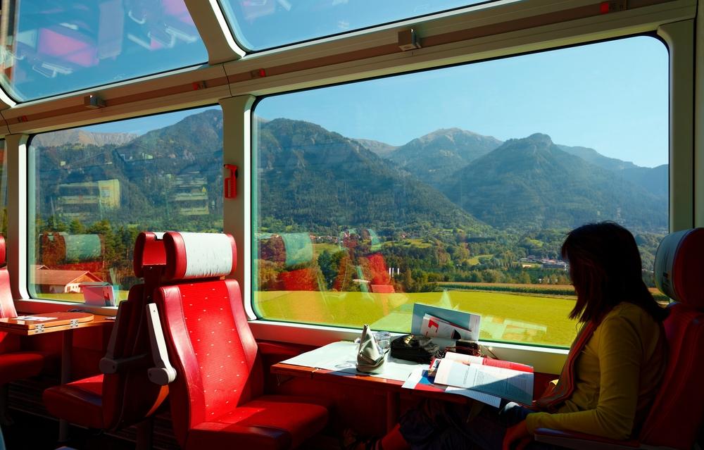 Călători în tren, privind peisajul prin ferestre mari