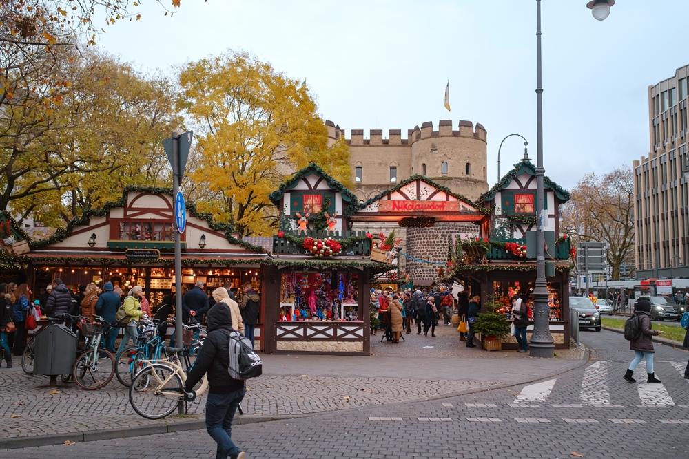 Vizitatori lângă standuri festive într-o piață urbană