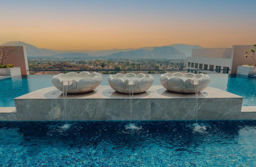 Piscină cu sculpturi rotunde și vedere spre dealuri