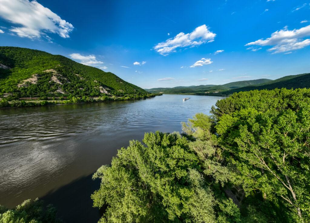 Dunărea între dealuri verzi, sub un cer albastru
